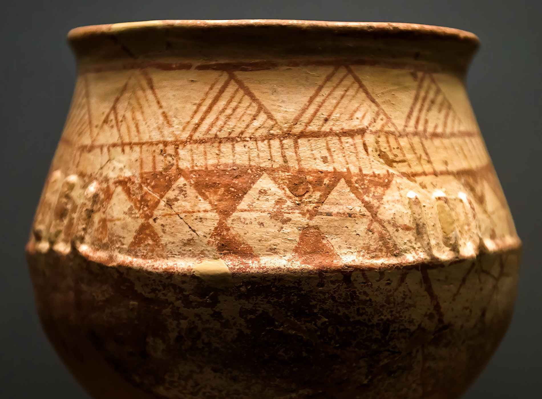 Ancient terracotta pot from the excavations in Greece. Painted archeological pottery. Remains of Ancient Greek culture. Antique ceramic with ornament. Old Greek patterned pottery on dark background.