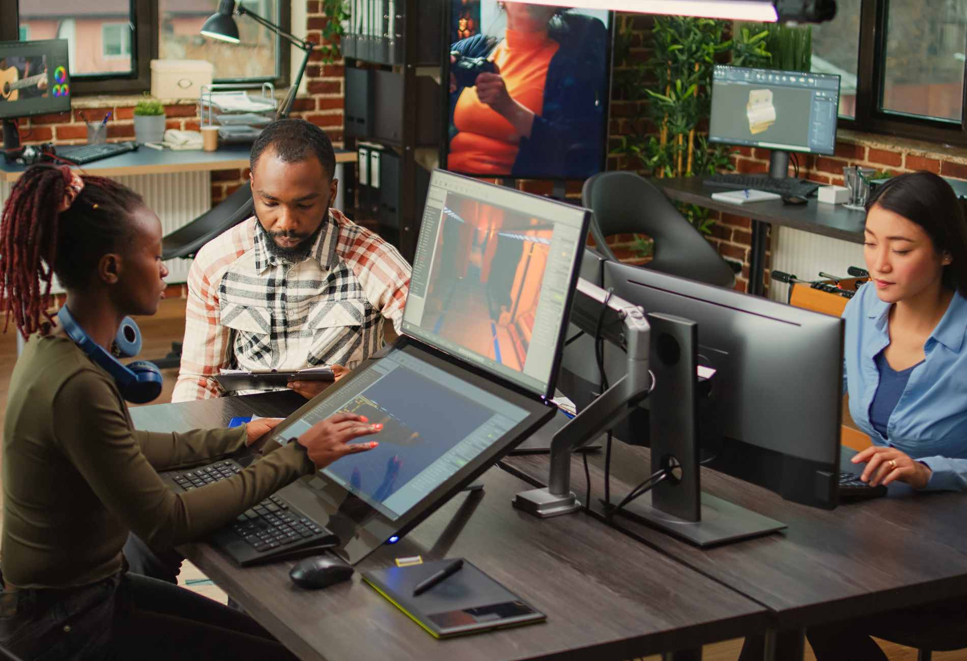 Team of african american people brainstorming game production ideas, looking at artistic development software. Creative agency colleagues analyzing CGI technique to create 3D modern project.