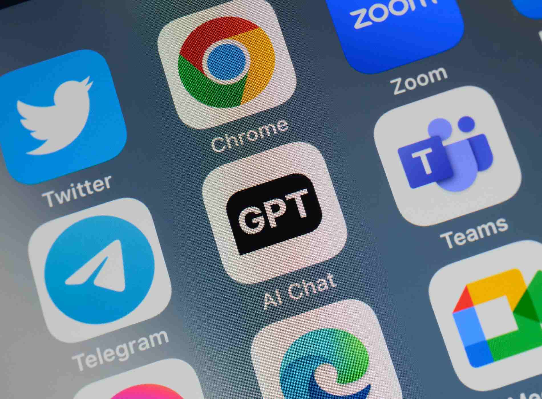 Close-up of of the icon of the ChatGPT artificial intelligence chatbot app logo on a cellphone screen. Surrounded by the app icons of Twitter, Chrome, Zoom, Telegram, Teams, Edge and Meet.