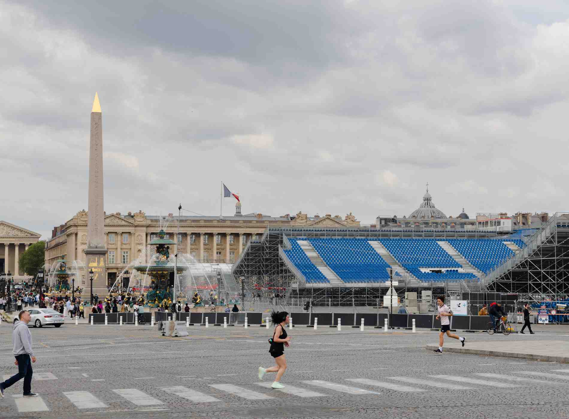 Paris, France :May 1'2024 - A grandstand stadium under the construction at Concorde square, obelisk with buildings. Preparation for Paris 2024 Olympics with people running and walking around the place