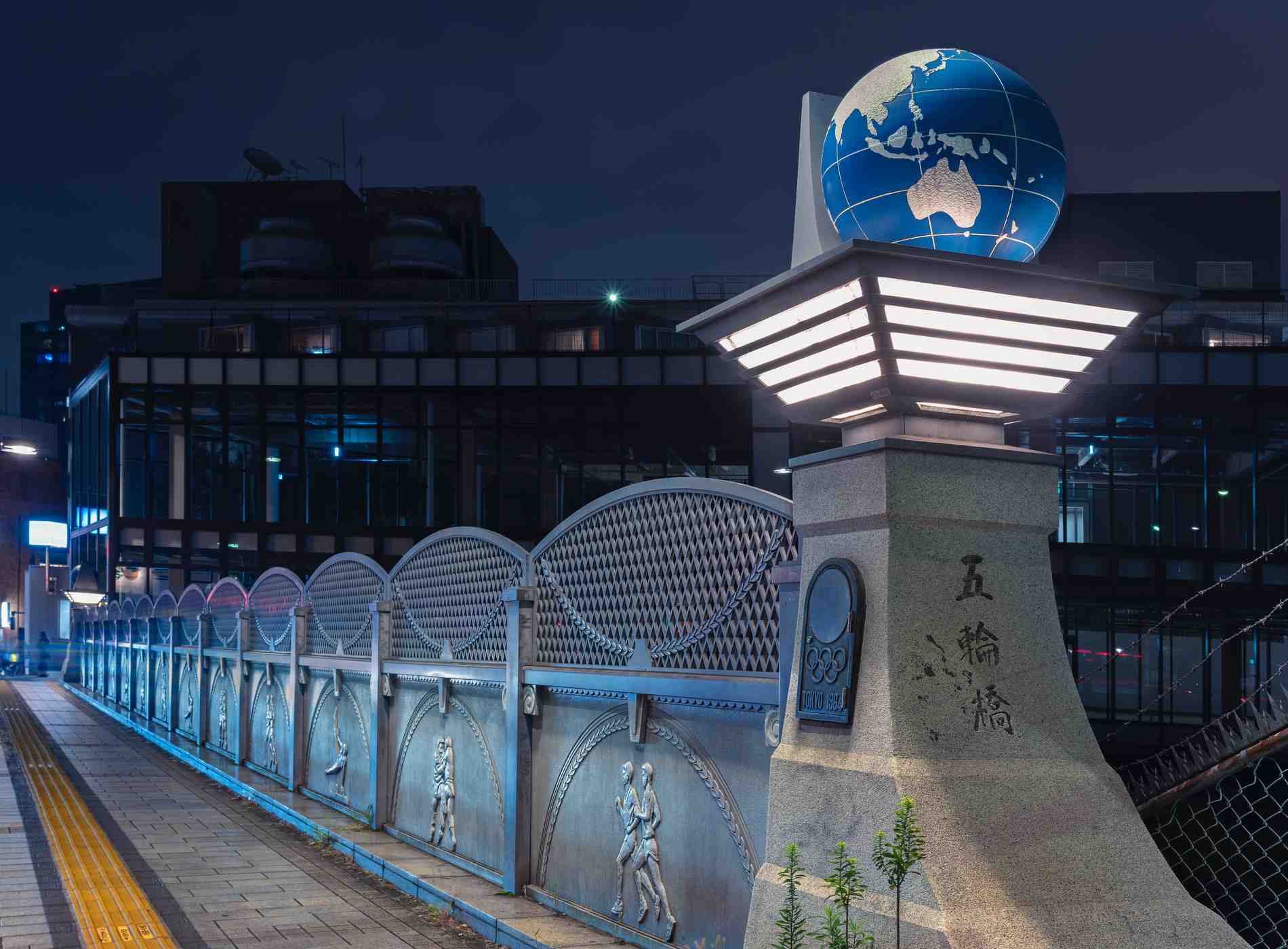 tokyo, japan - november 02 2019: The Olympic Bridge named Gorinbashi created for 1964 Summer Olympics in Harajuku district and decorated with an earth globe and reliefs depicting athletes at night.