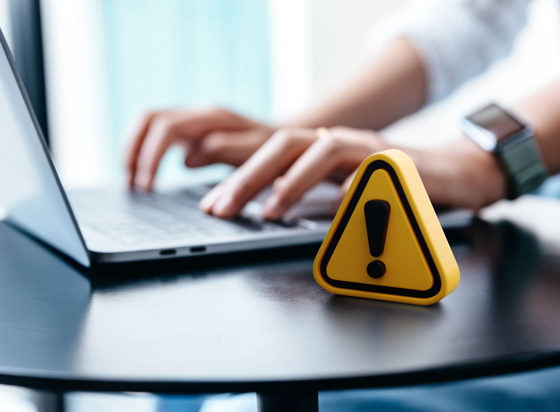 Warning sign placed on a table while businesswoman work.