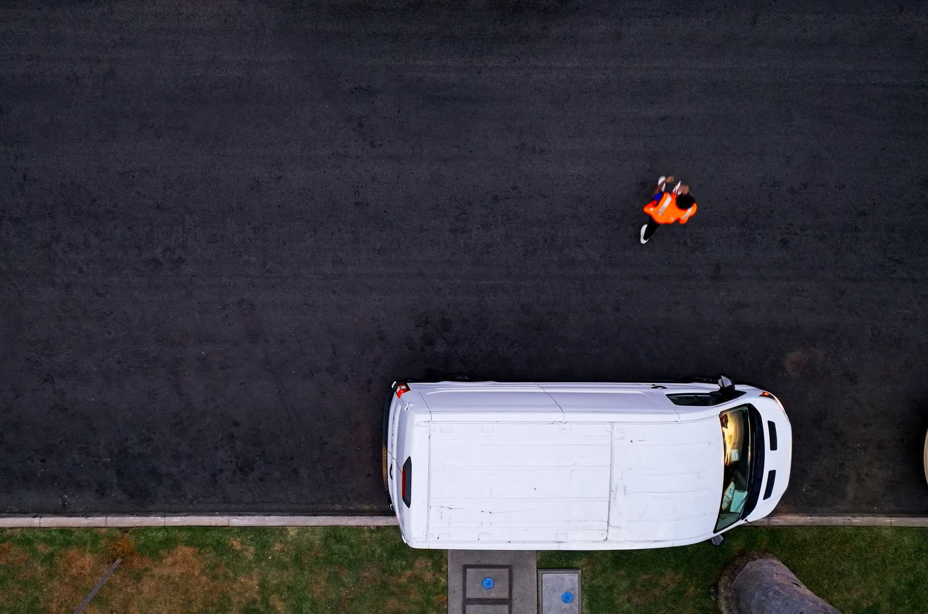 Aerial shot directly above a white delivery van on a residential street in Los Angeles, California.