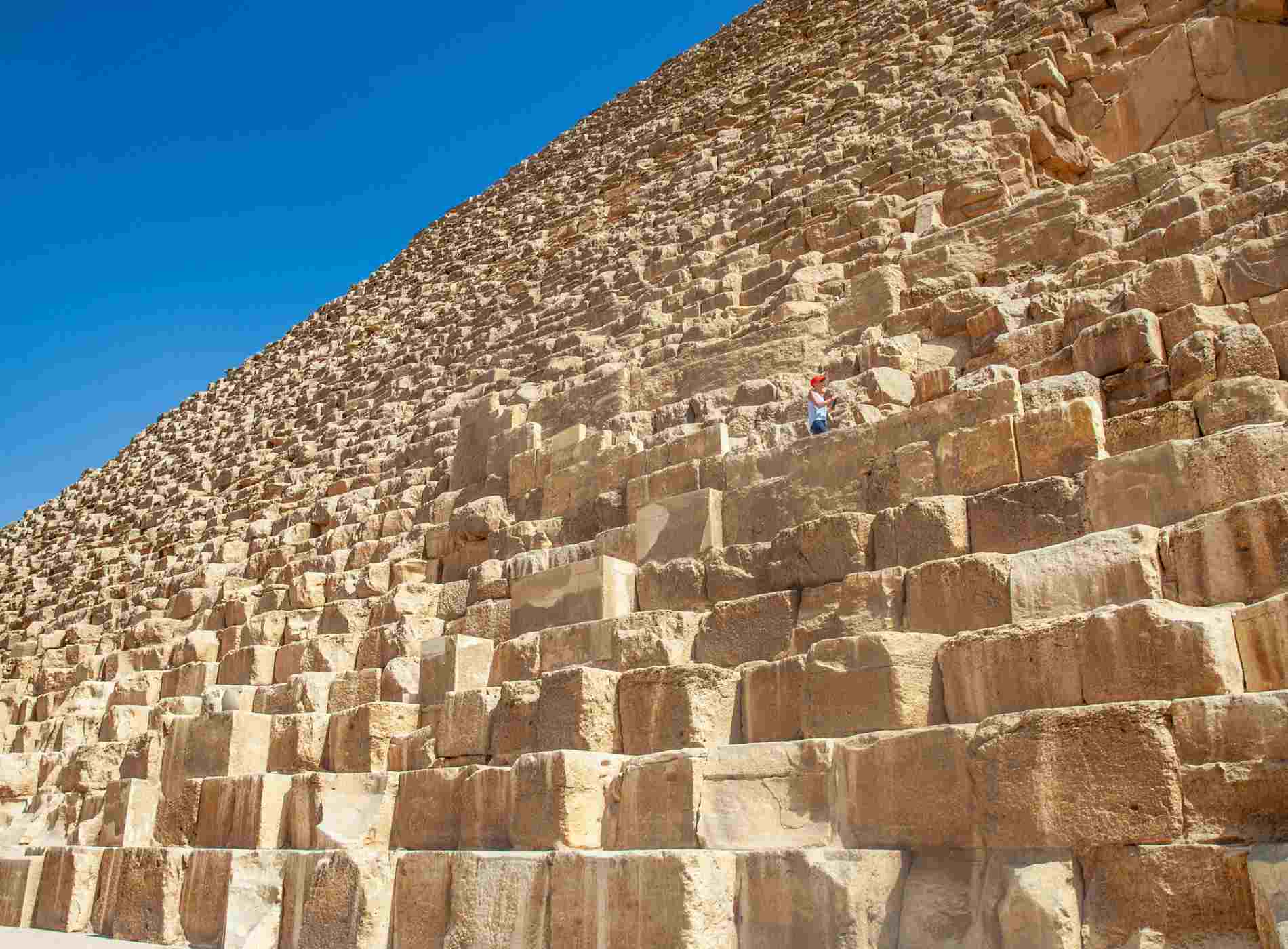 Woman Tourist Exploring Kheops Pyramid Exterior.