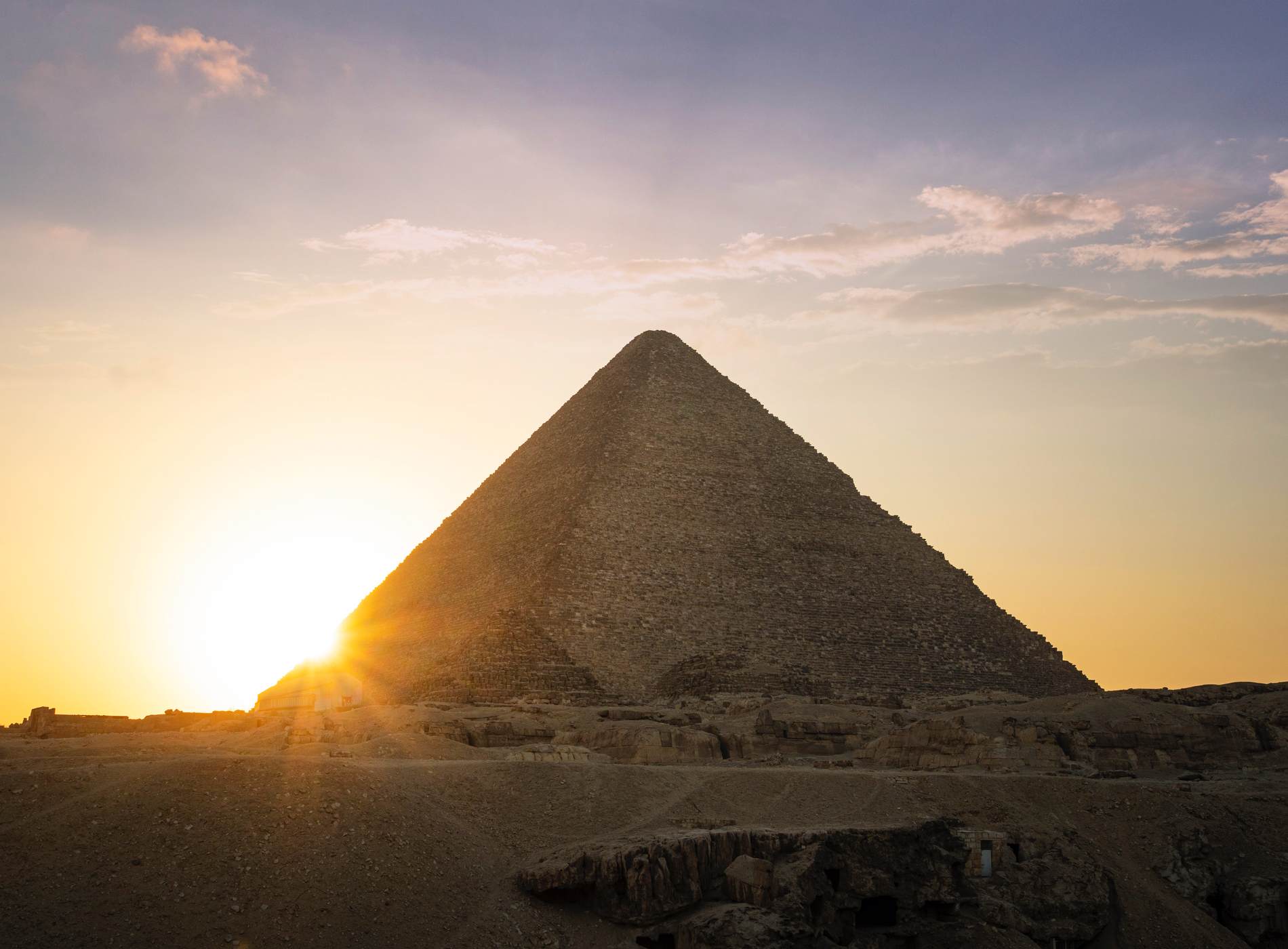 Archaeological complex of the Great Egyptian Pyramids is located on the Giza plateau. Pyramids of Chephren Khafra in the night light at sunset. sun sets behind the pyramid.