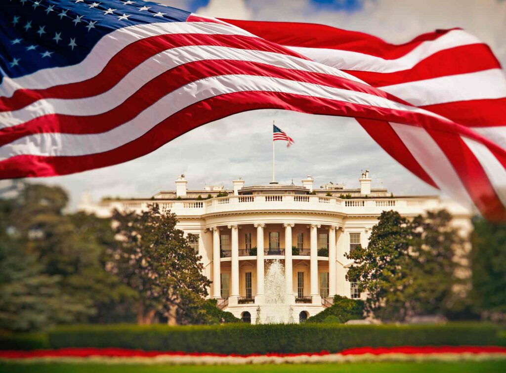 The White House in Washington DC with waving United States flag